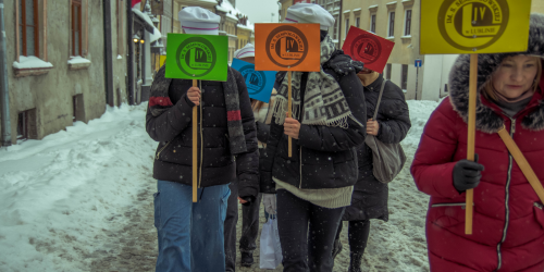 Grupa młodych ludzi z tabliczkami IV LO, w czapkach Arciszanek na Starym Mieście