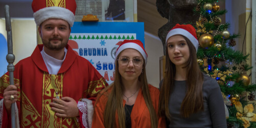 Mikołaj i dwie dziewczyny w czapkach mikołaja