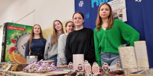 Młode dziewczyny przy stolikach ze świątecznymi wypiekami