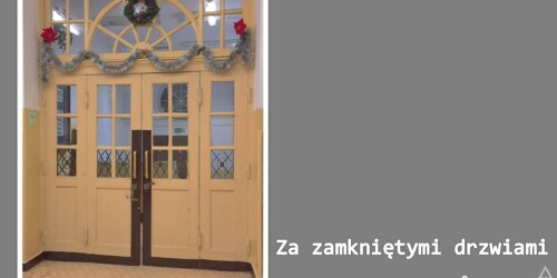 Beżowe drzwi wejściowe do szkoły, na górze drzwi świąteczne ozdoby