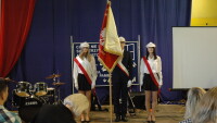 Nowy poczet sztandarowy IV LO, dwie dziewczyny i chłopak, biało-czerwone elementy, czapki arciszanek, sztandar IV LO